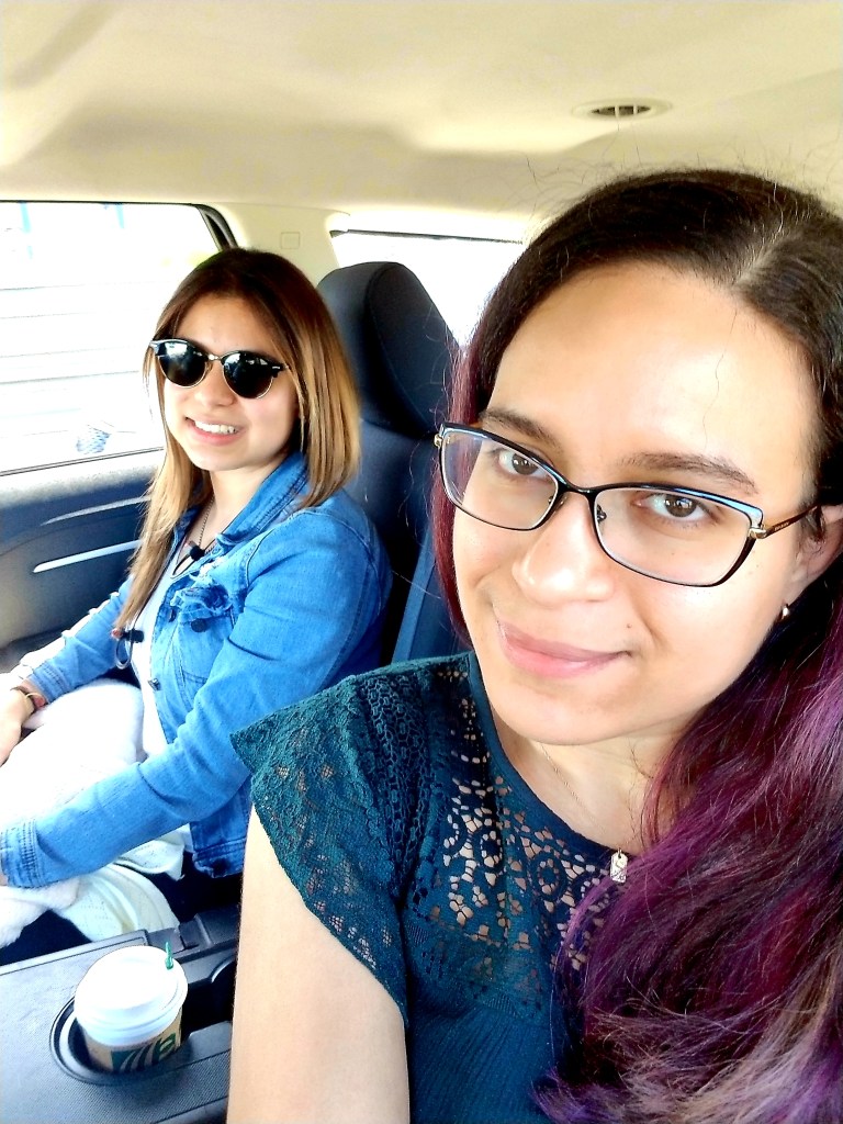 Two brunettes smile in the back of an Uber.