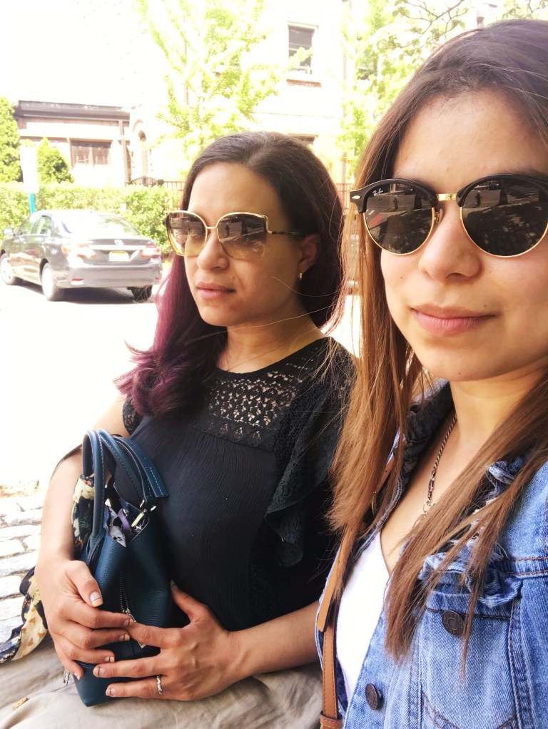 Two brunettes half-smile as they sit.