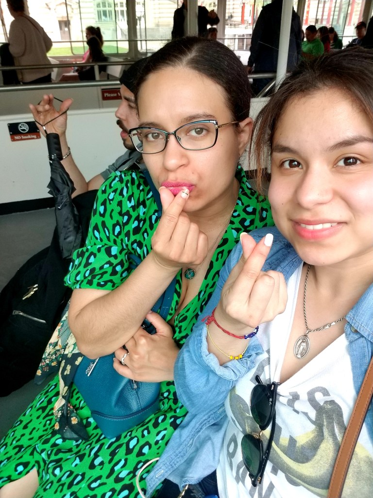 Brunettes smile and make hearts with their fingers.