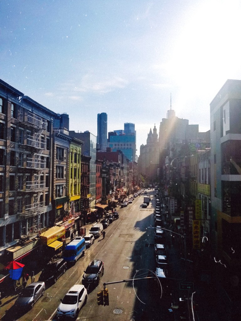 A view of Market Street, lined with colorful buildings, from the Manhattan Bridge Pedestrian Path.